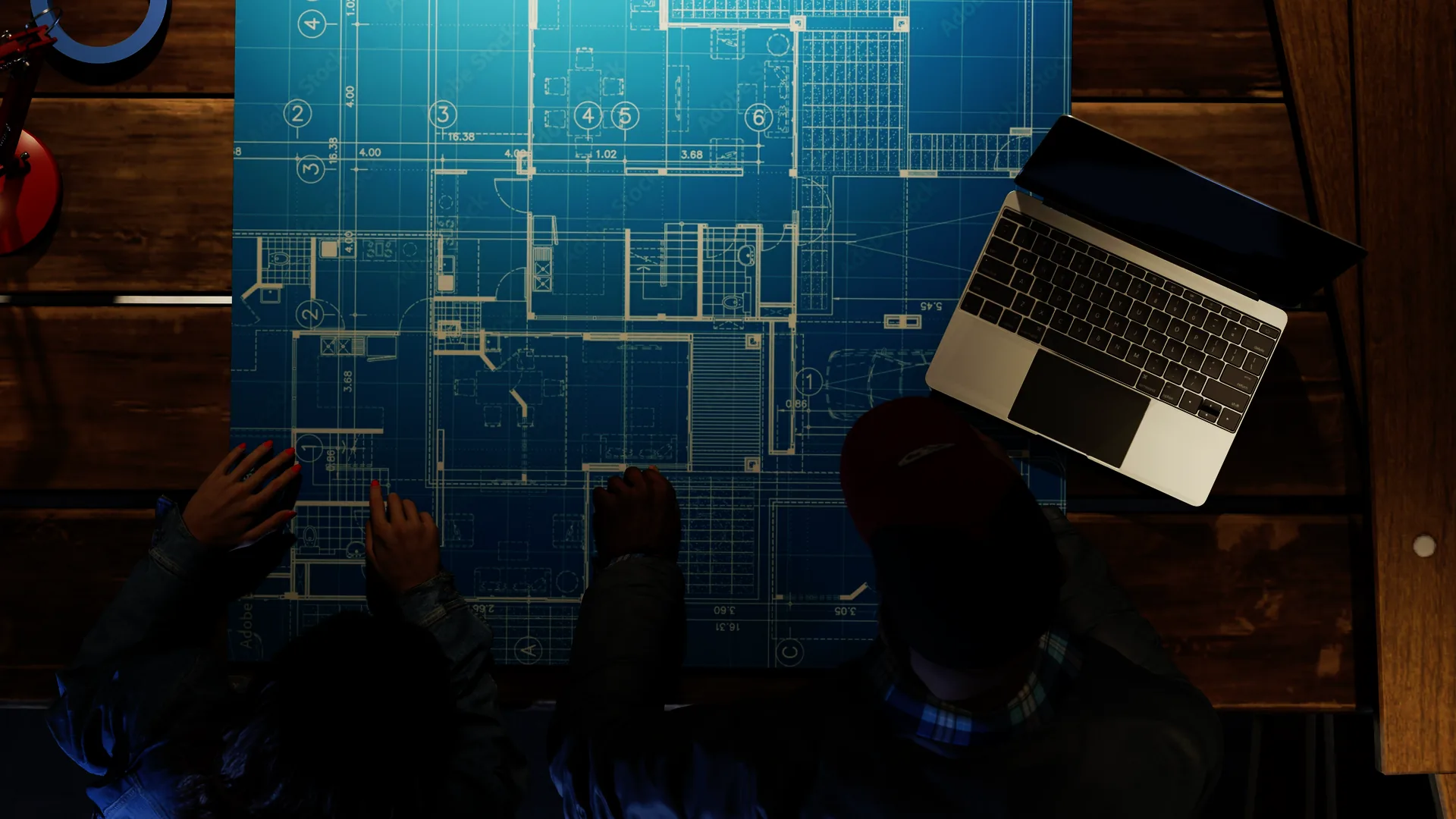 set.a.light 3D overhead render of blueprints on a wood table with a laptop and hands on the plans