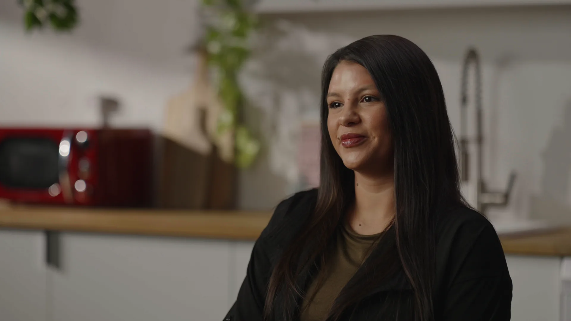 B camera production frame: tight three-quarter angle of the interview subject