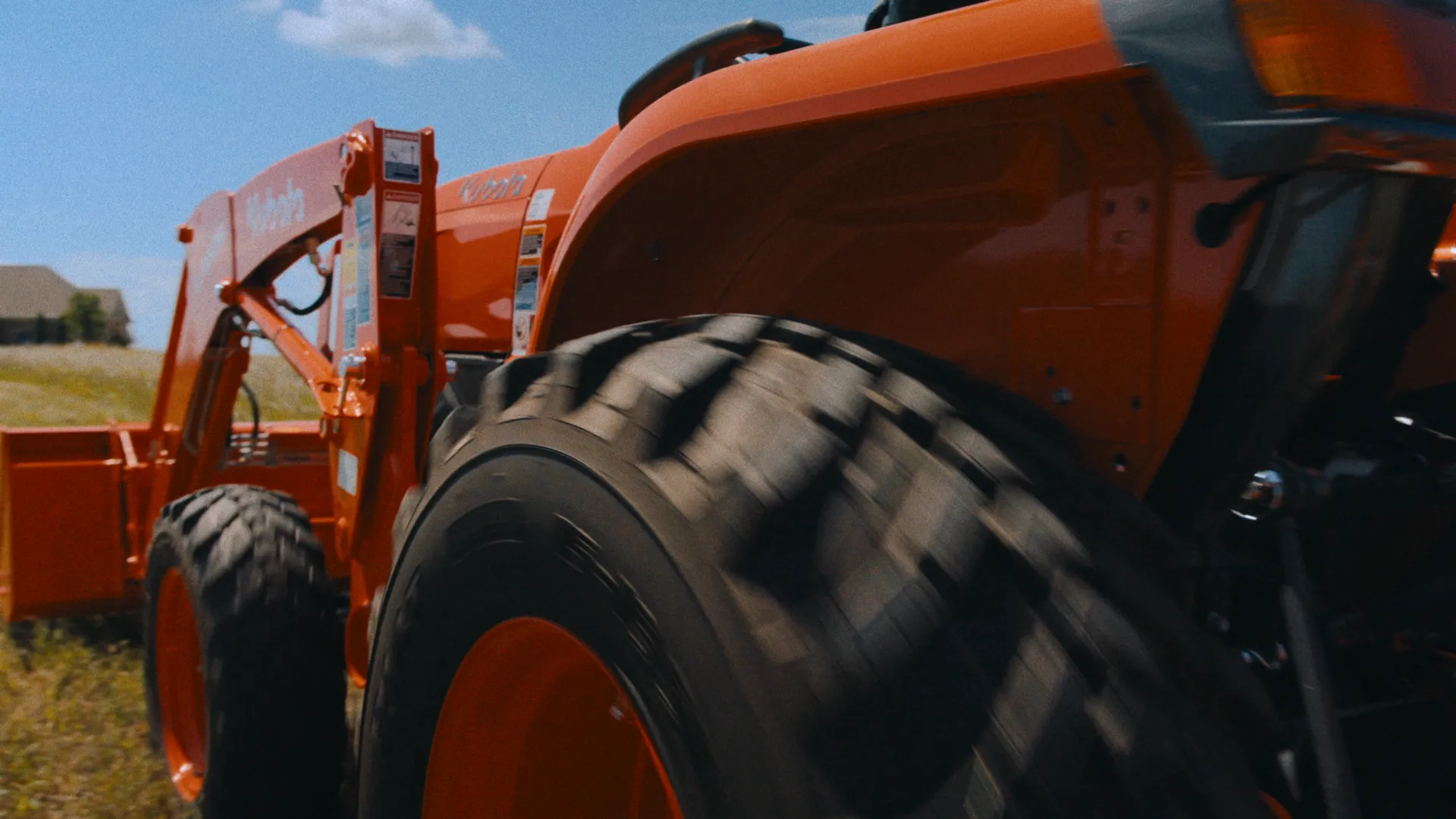 Ground-level tire and fender detail as a Kubota rolls past