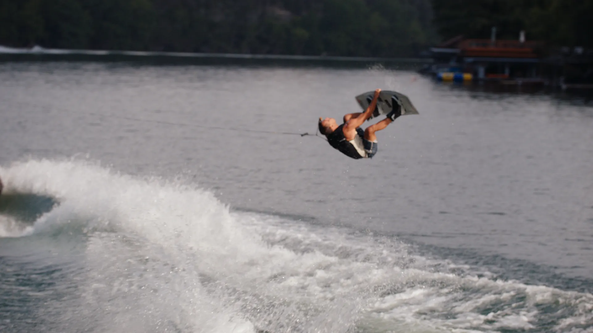 Wakeboarder in an inverted flip behind the boat