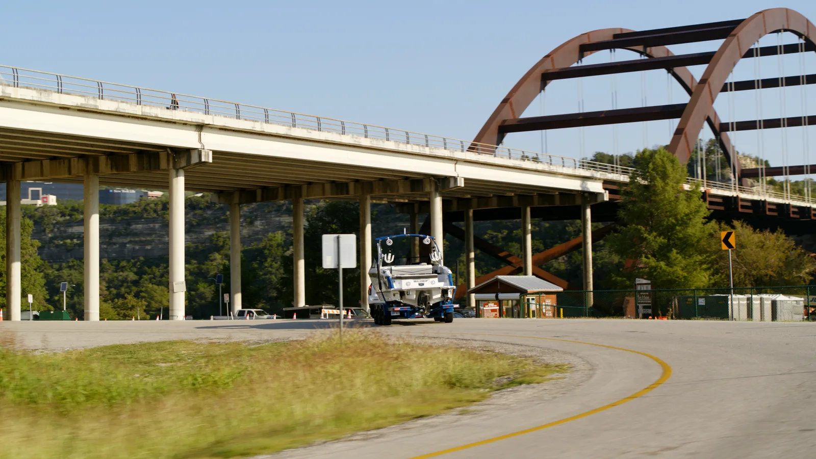 Suburban towing a Cobalt boat under the Pennybacker Bridge arch