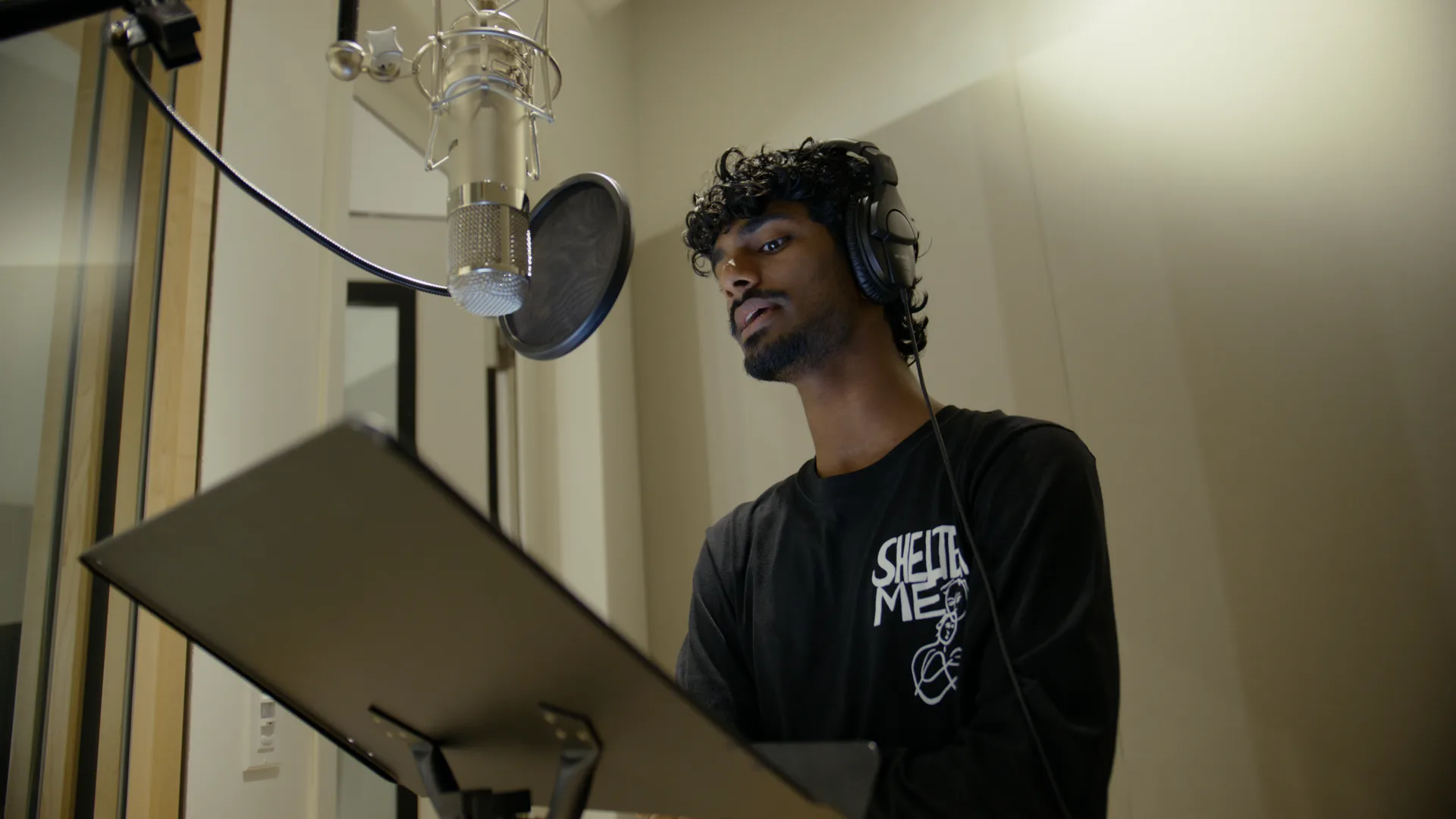 Vocalist at the booth mic reading the score