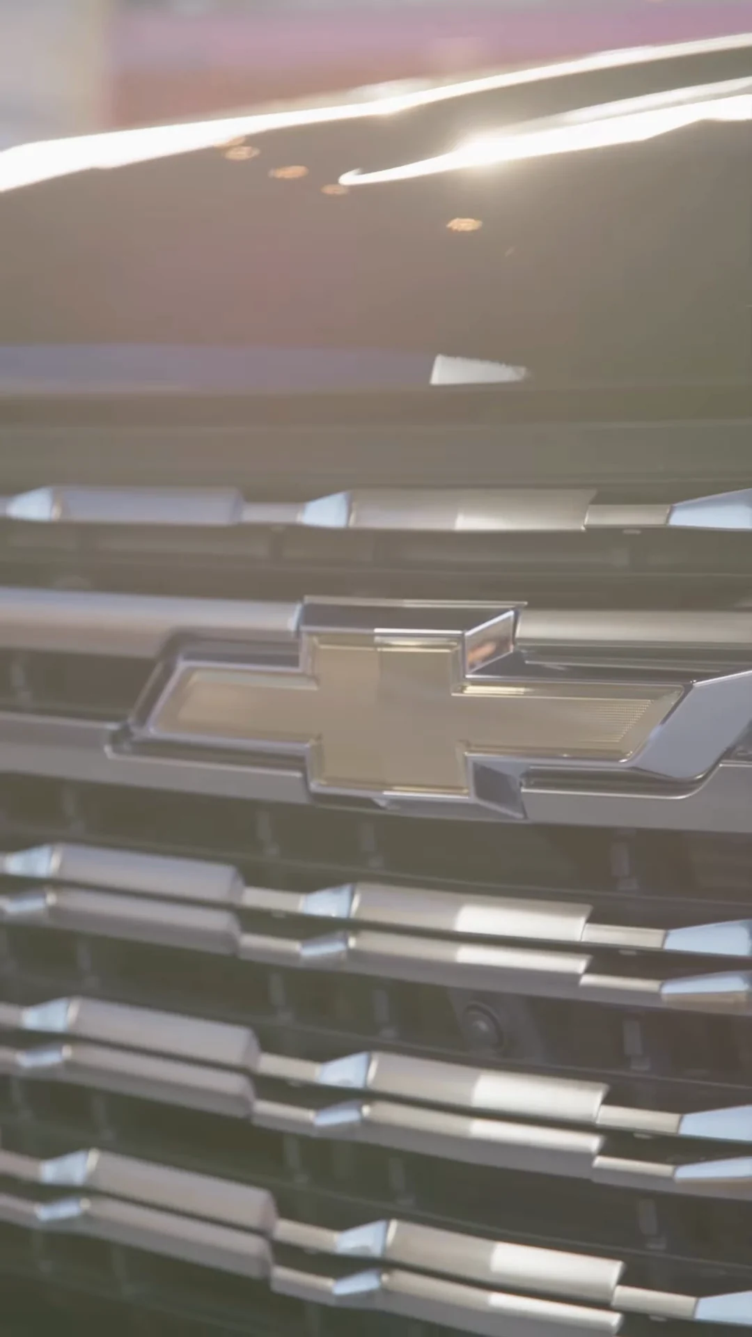 Chevrolet bowtie on a chrome Silverado grille catching the light