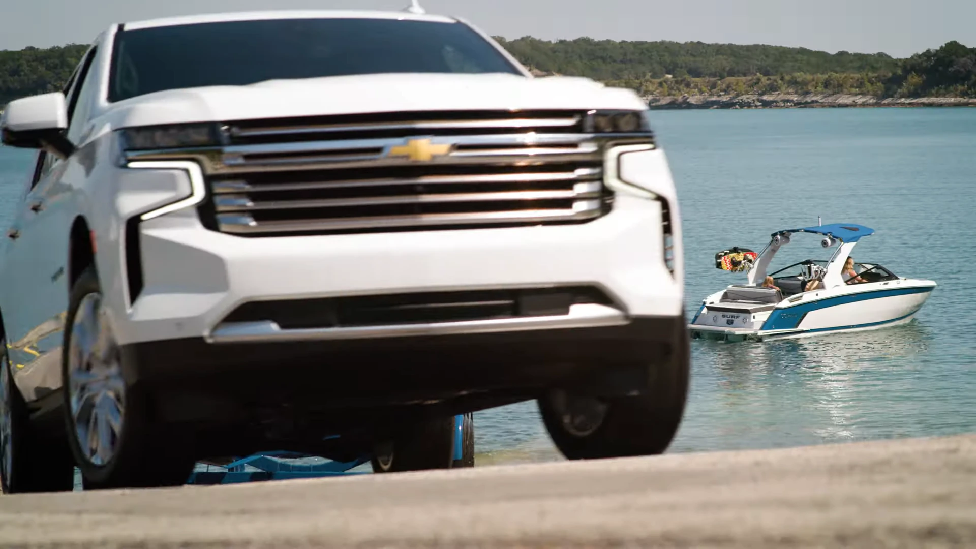 A dad watching from the boat as his daughter surfs the wake