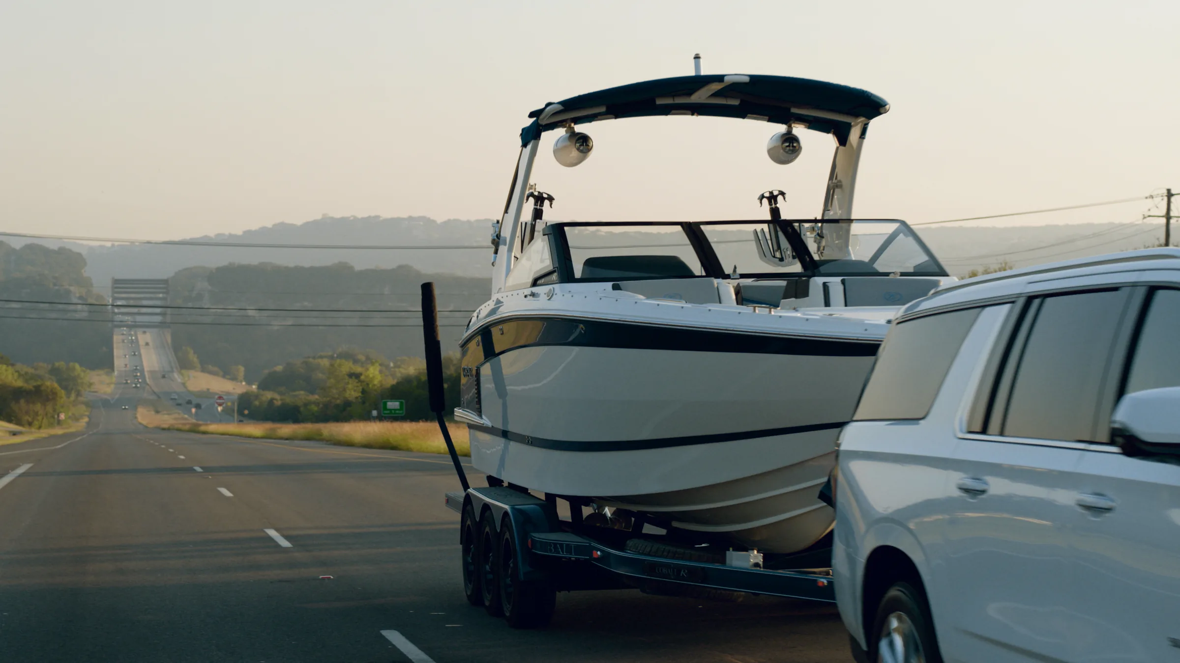 The Cobalt's bow on the trailer against hazy Hill Country, the Pennybacker Bridge far behind