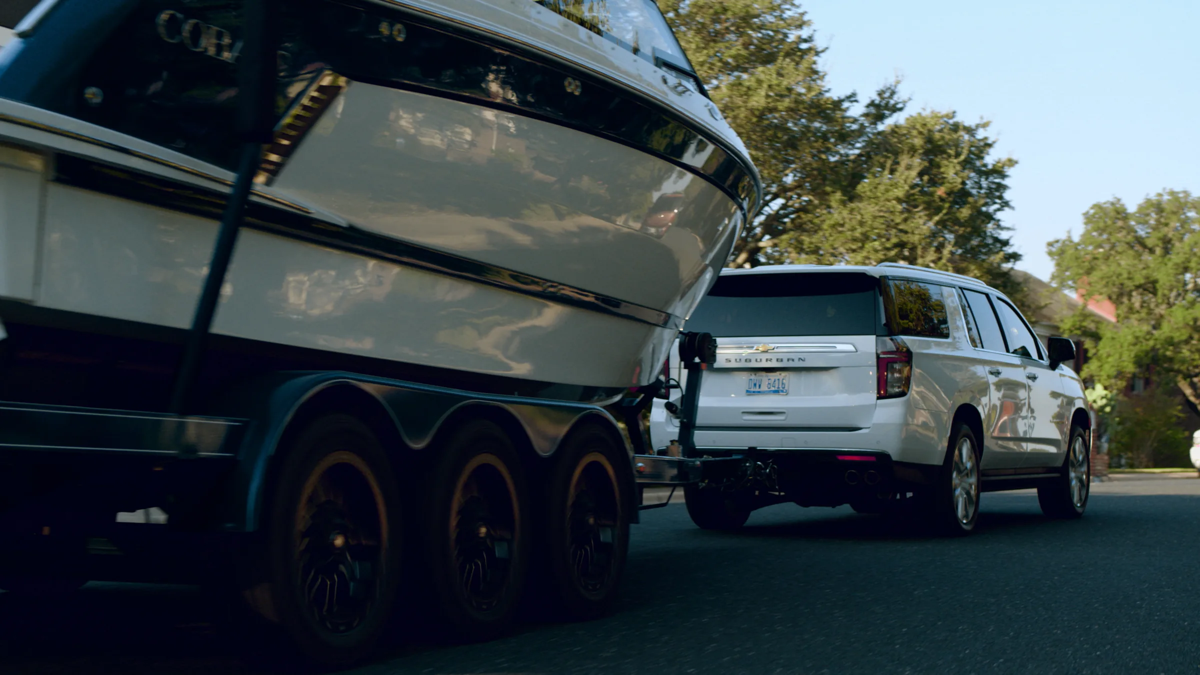 Low angle under the Cobalt's hull on the trailer, the Suburban ahead