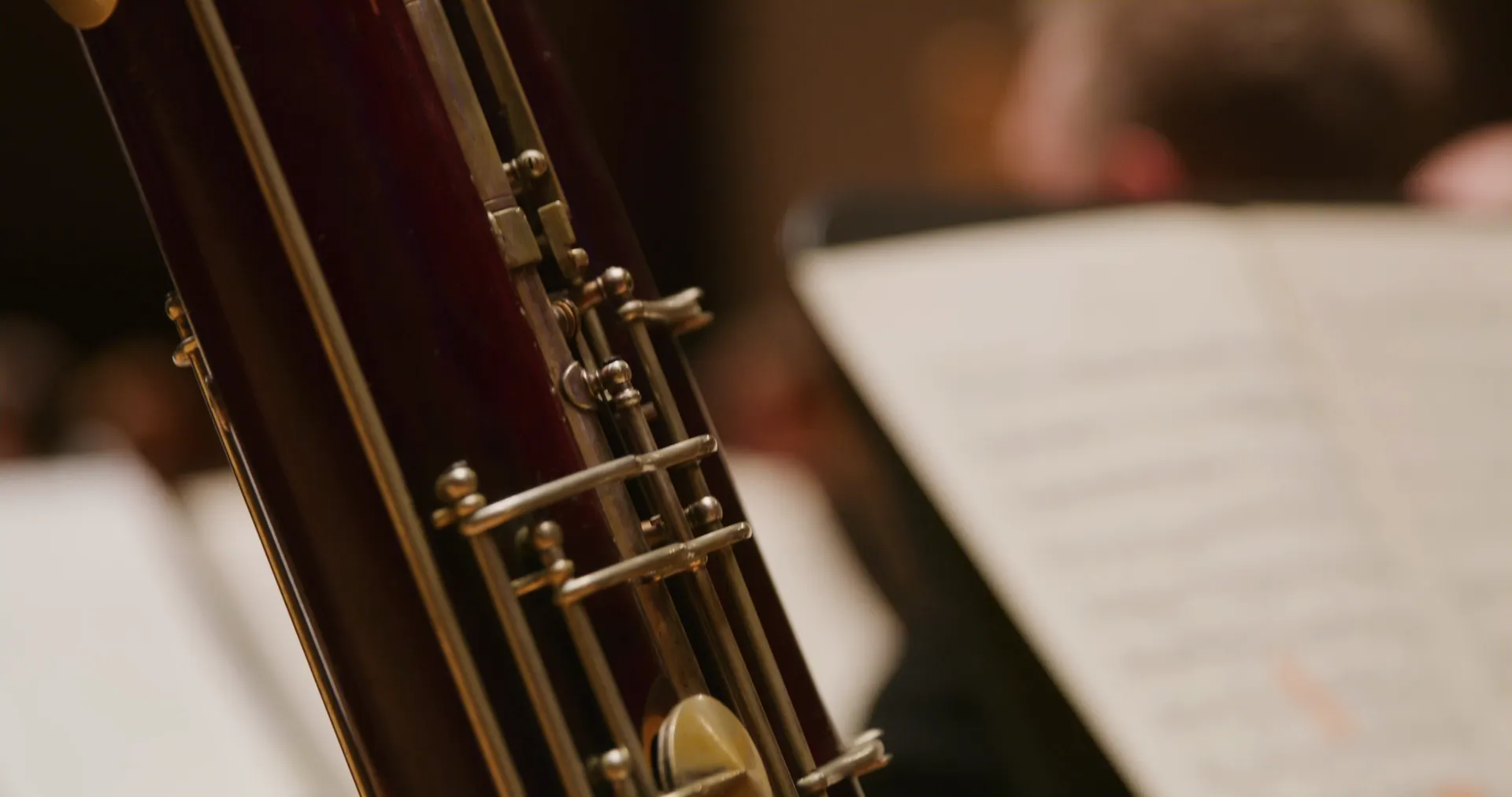 Close on a bassoon beside a page of sheet music
