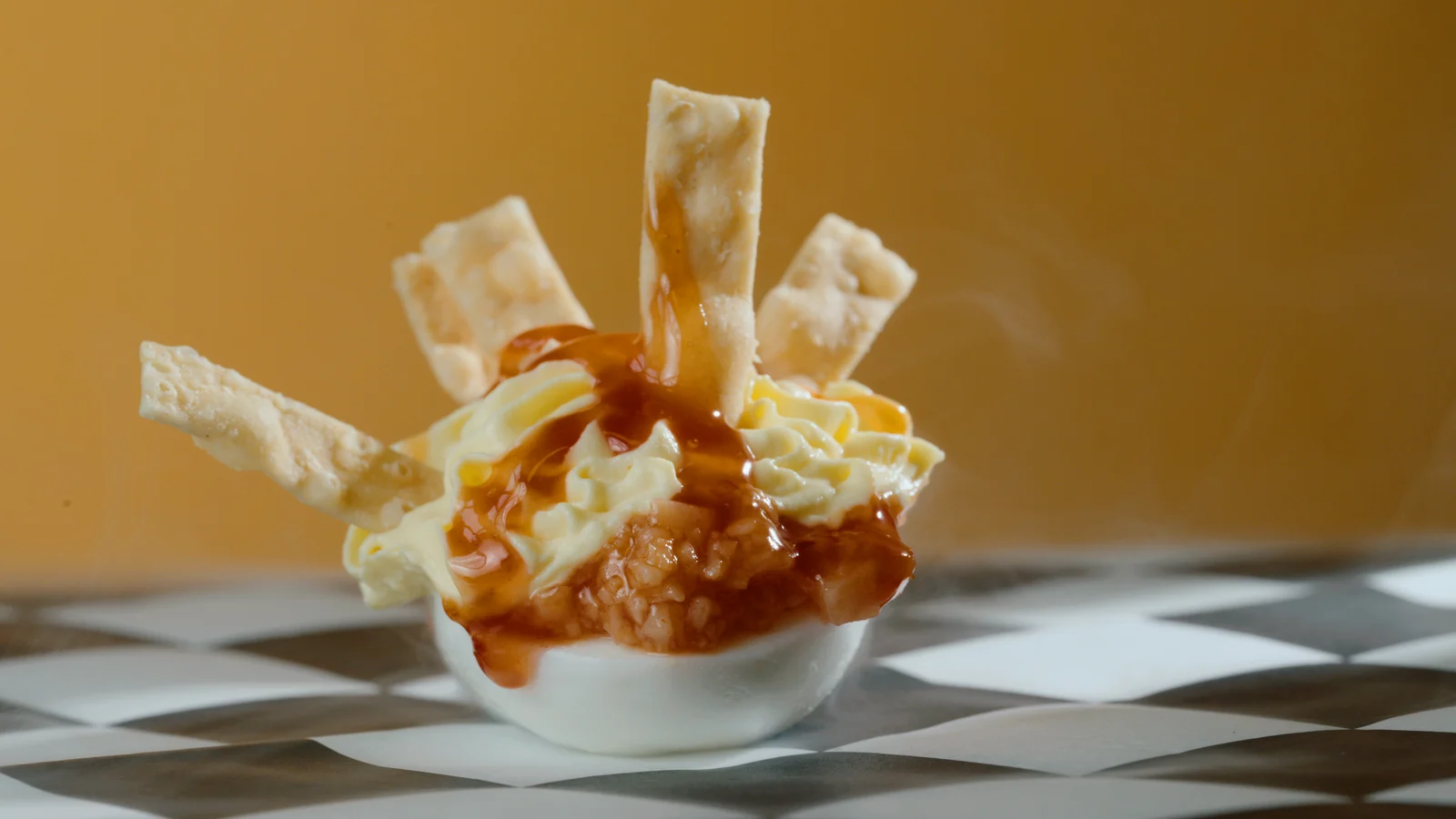 Crispy-strip deviled egg with a sauce drizzle against the gold sweep