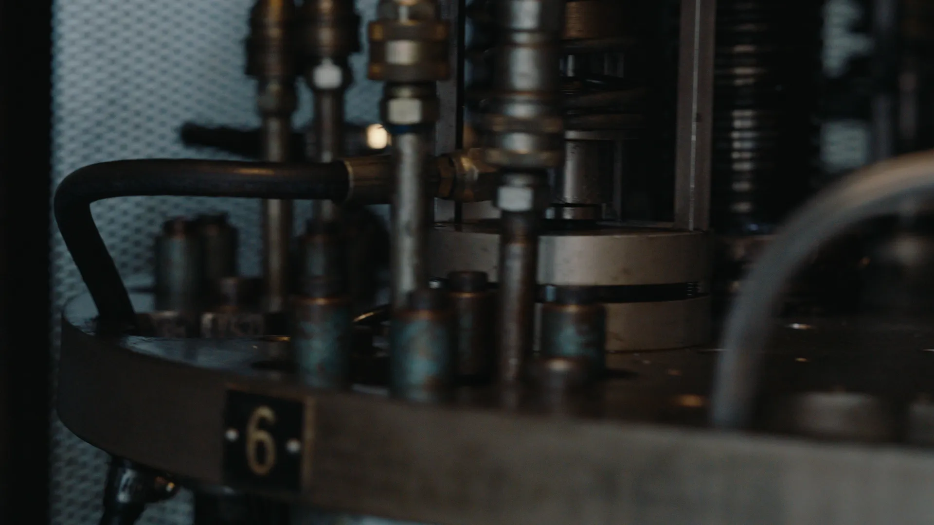 Close detail of numbered filling heads on a rotary machine