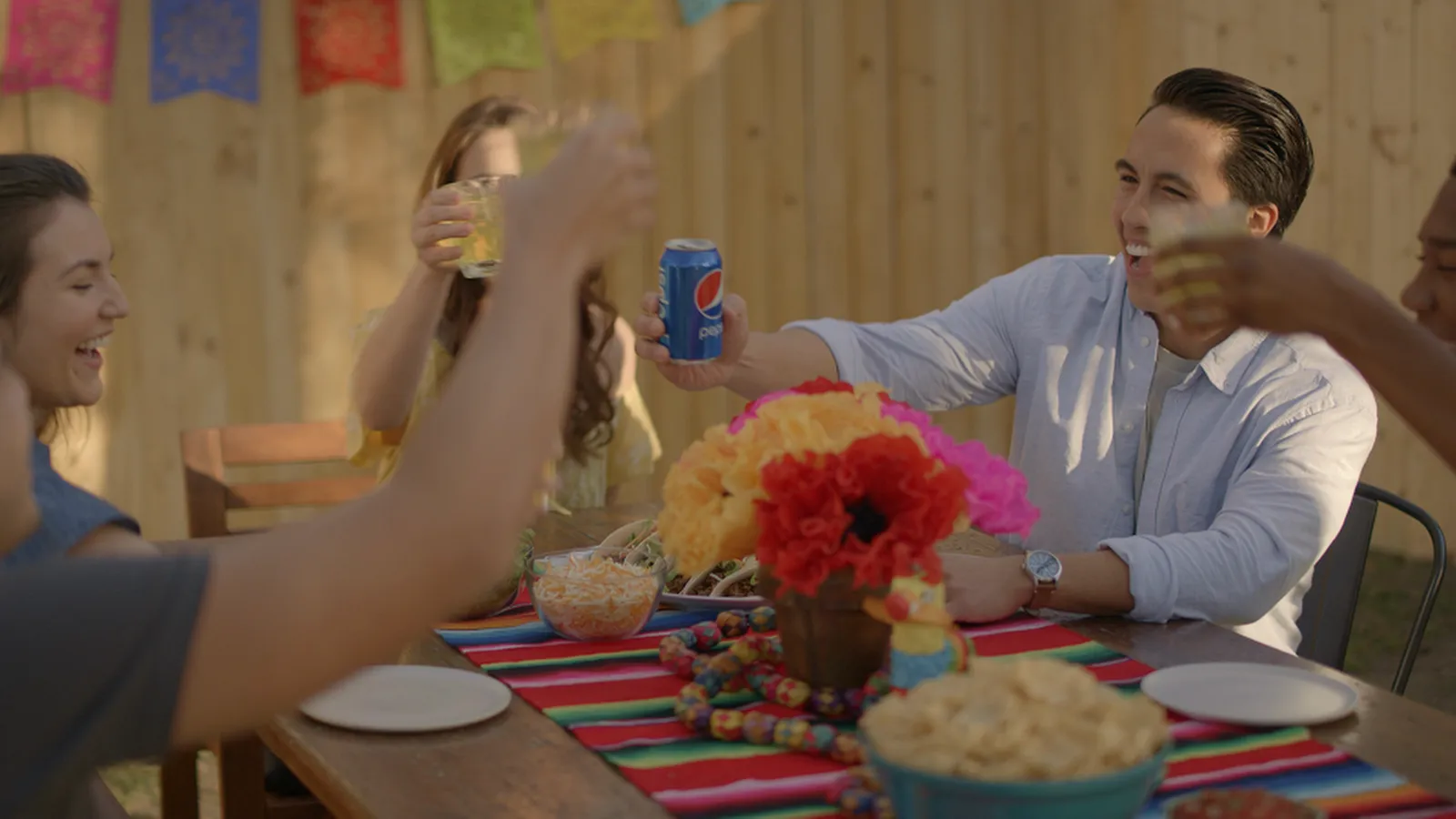 Friends raising drinks at a backyard fiesta table