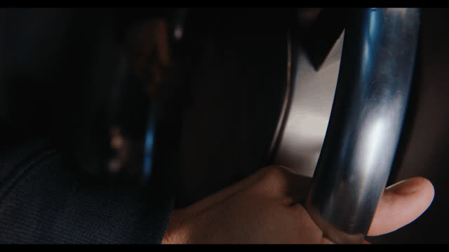 A hand turning the wheel of a vault door in low light