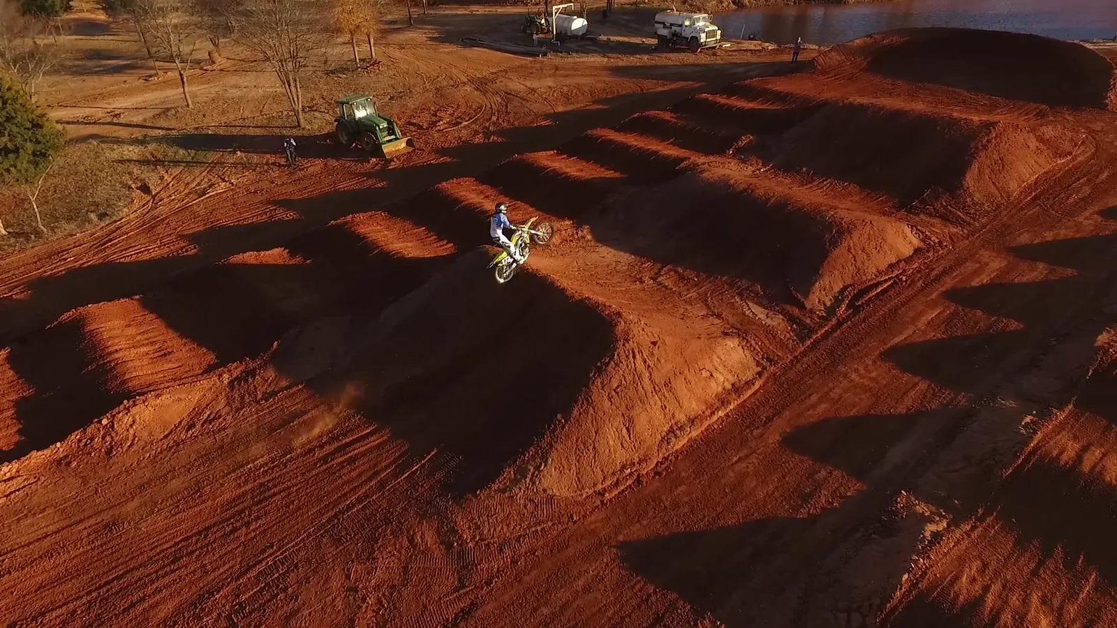 Overhead aerial of a rider with a long shadow across the track