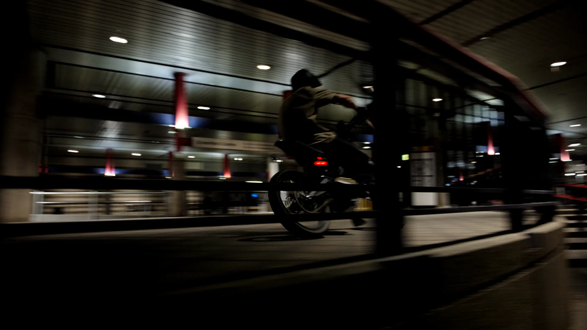 A rider cutting through a lit parking garage at night