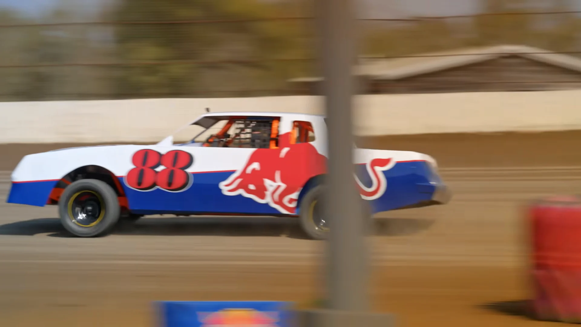 The number 88 Red Bull stock car tracked past the outside wall in motion blur