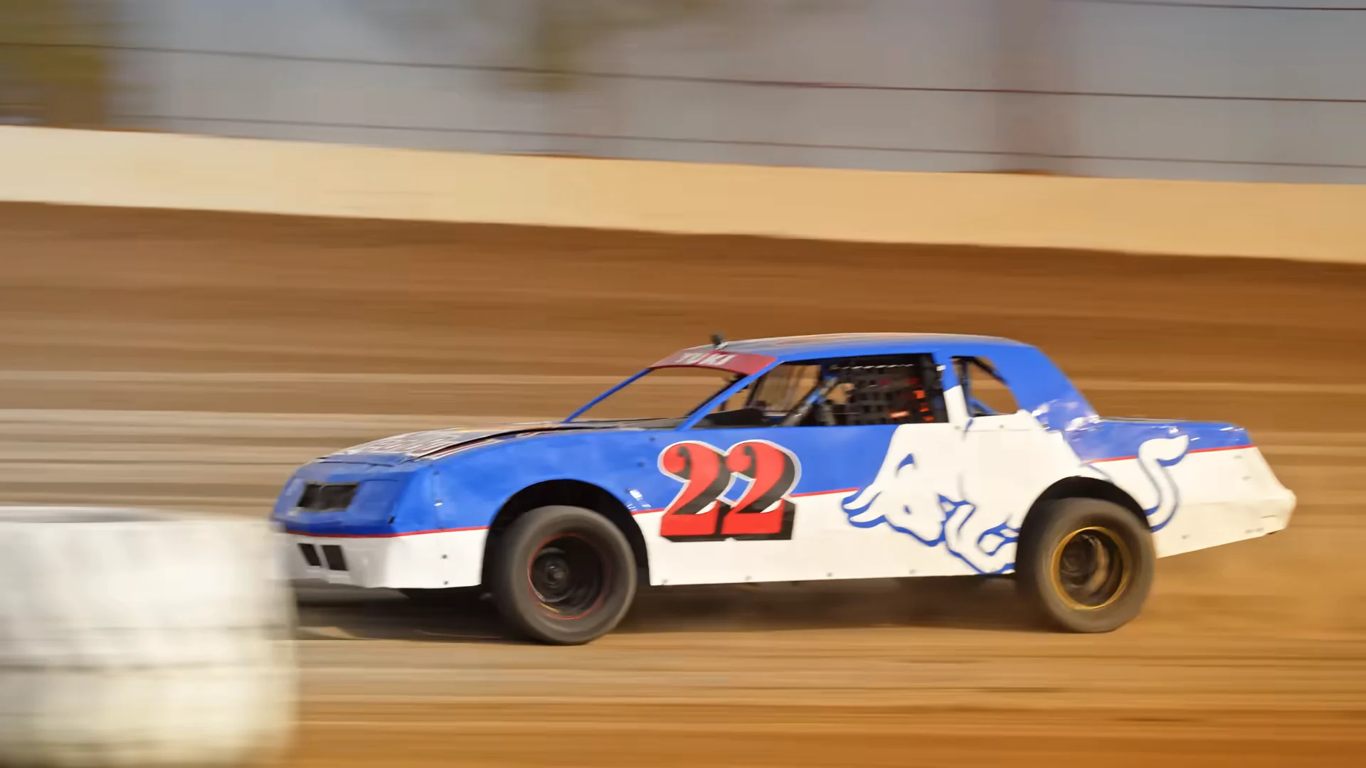 The number 22 car sliding past a tire marker on the dirt