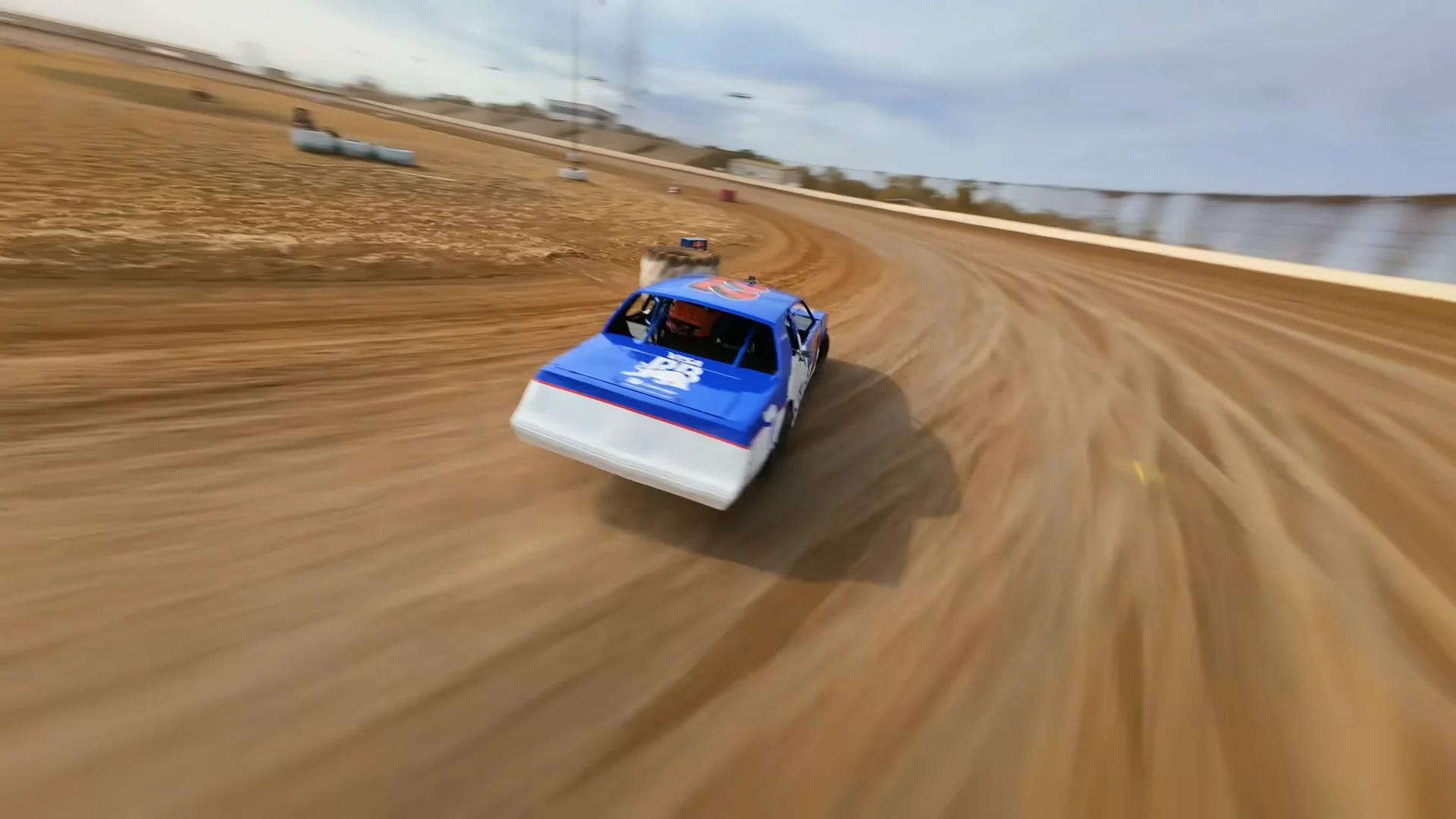 Chasing the number 22 car from behind as it drifts through a dirt corner