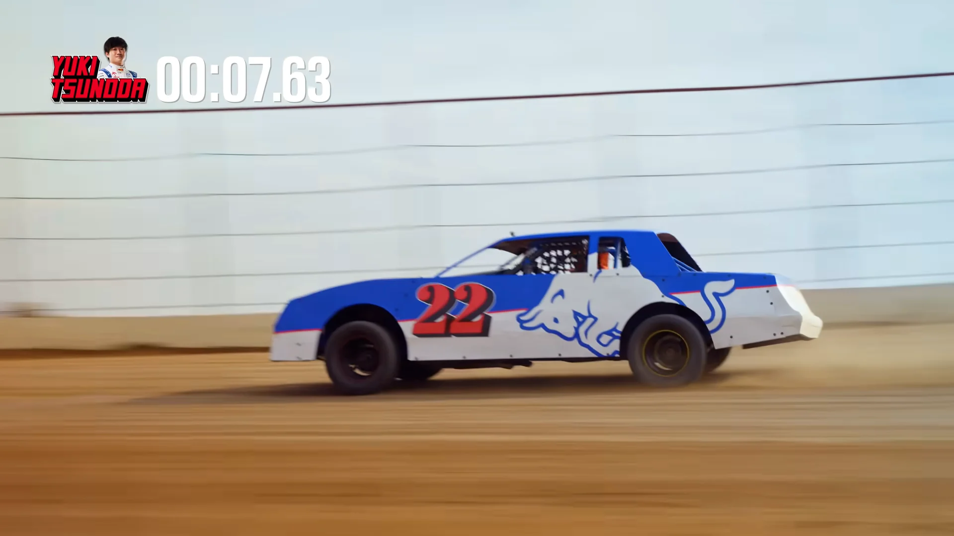 An FPV drone chasing a stock car down the front stretch wall