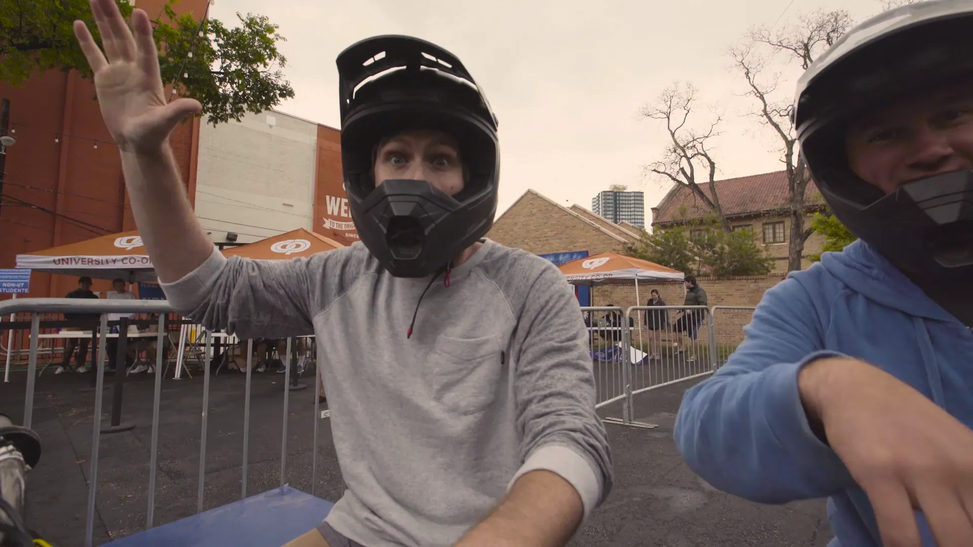 A rider in a full-face helmet waving to the camera
