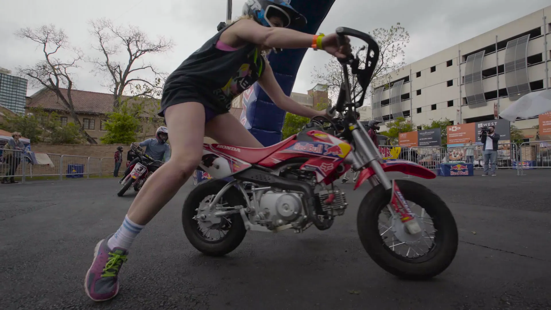 A rider pushing a mini bike through a turn, shot low
