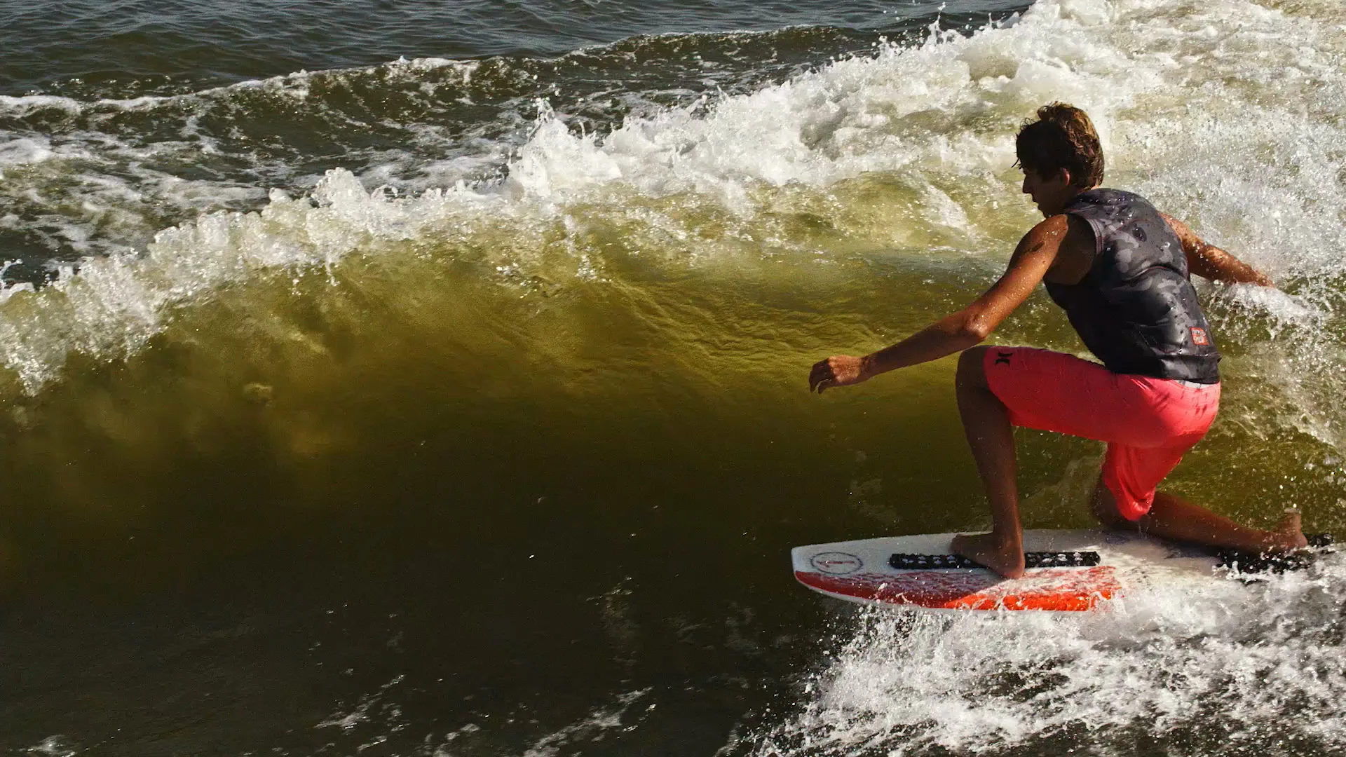 Parker Payne crouched low on a translucent green wave