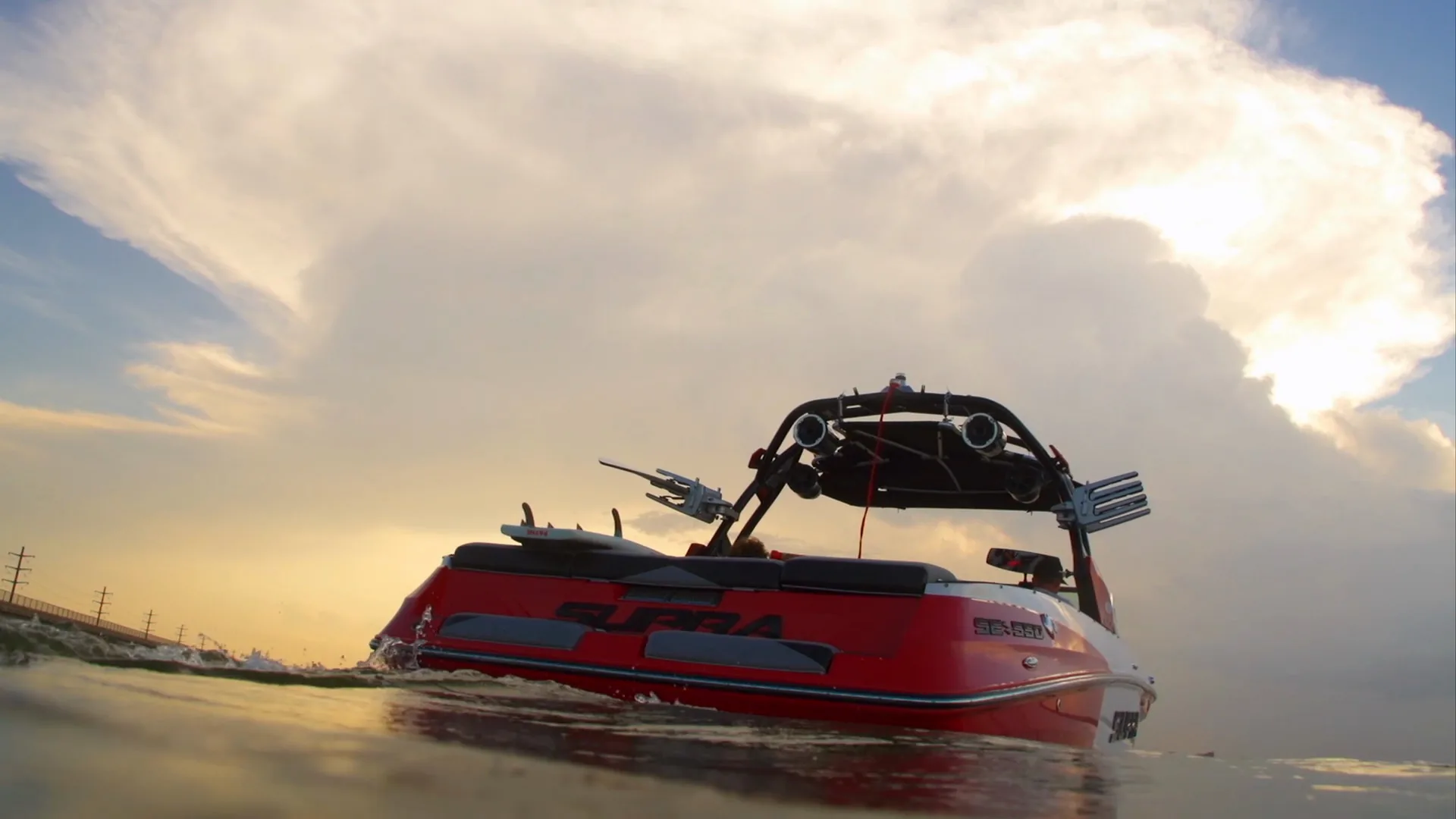 The Supra's stern from the waterline at sunset, golden clouds behind