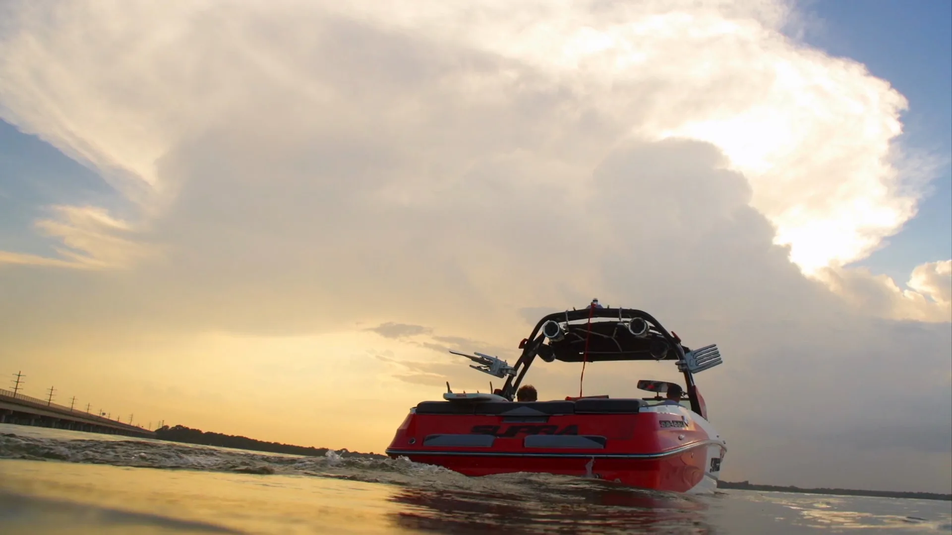 The Supra under a huge sunset cumulus cloud, seen from the water