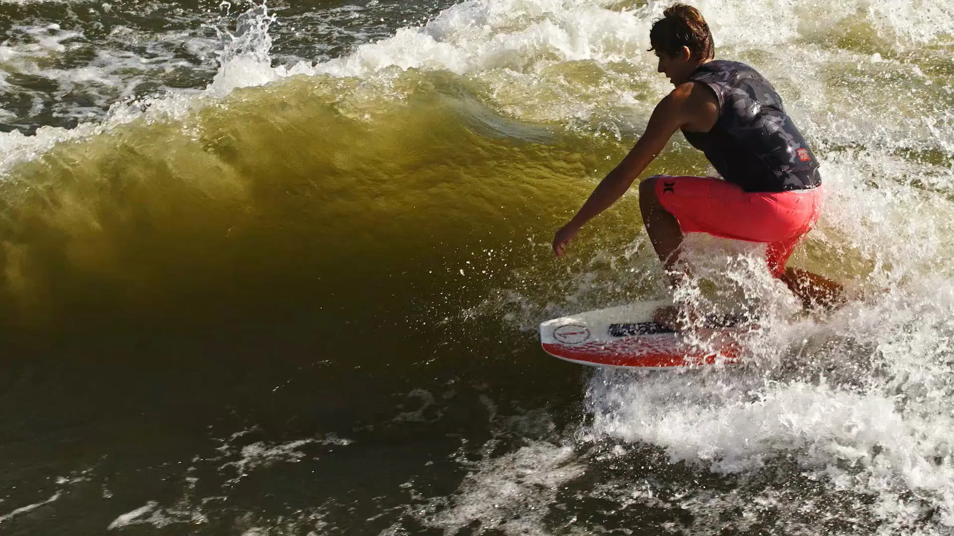 Close on Parker Payne carving against a green wall of wake