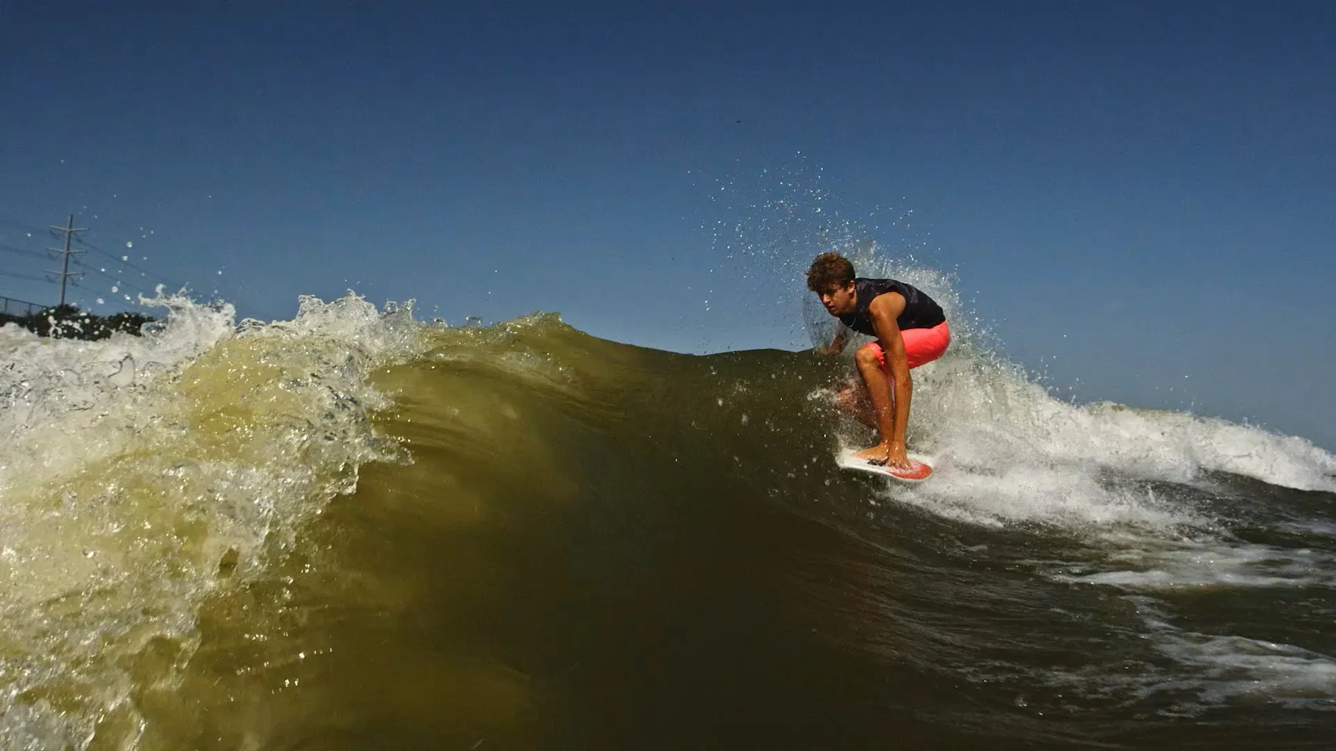 Parker Payne crouched on the crest of the wave