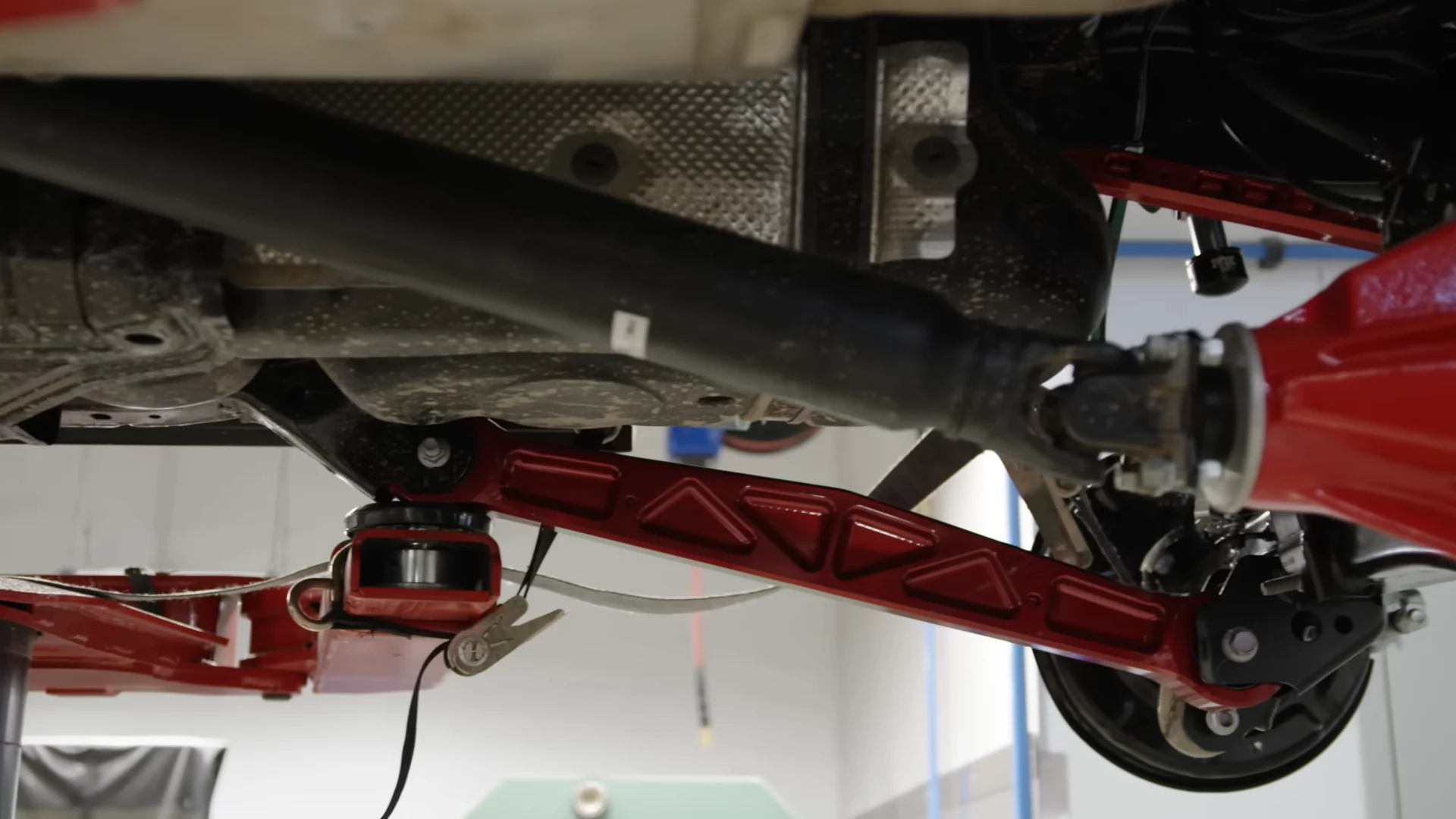 Looking up at the red TRD control arm and driveshaft under the truck