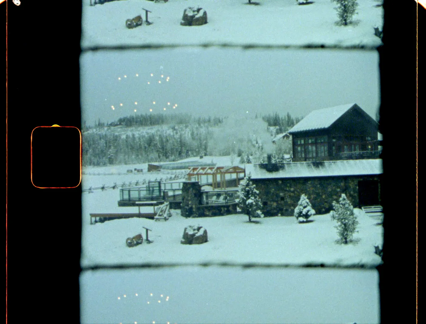 A log ranch house and outbuildings under fresh snow