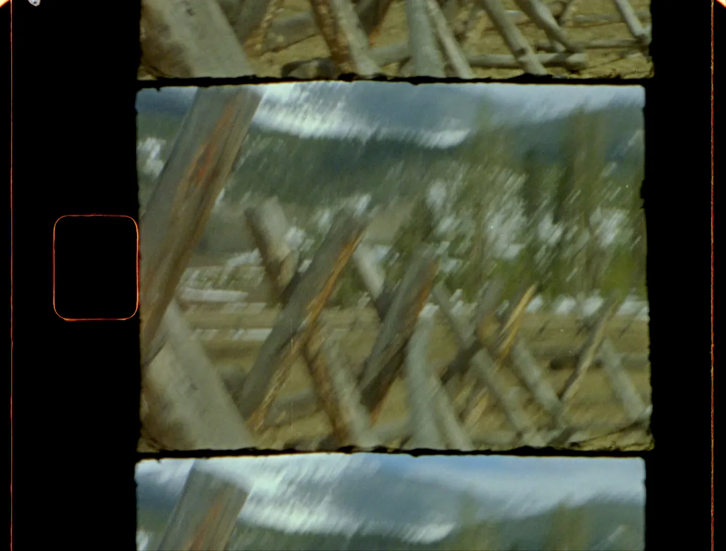 A weathered buck-and-rail fence zigzagging toward the mountains