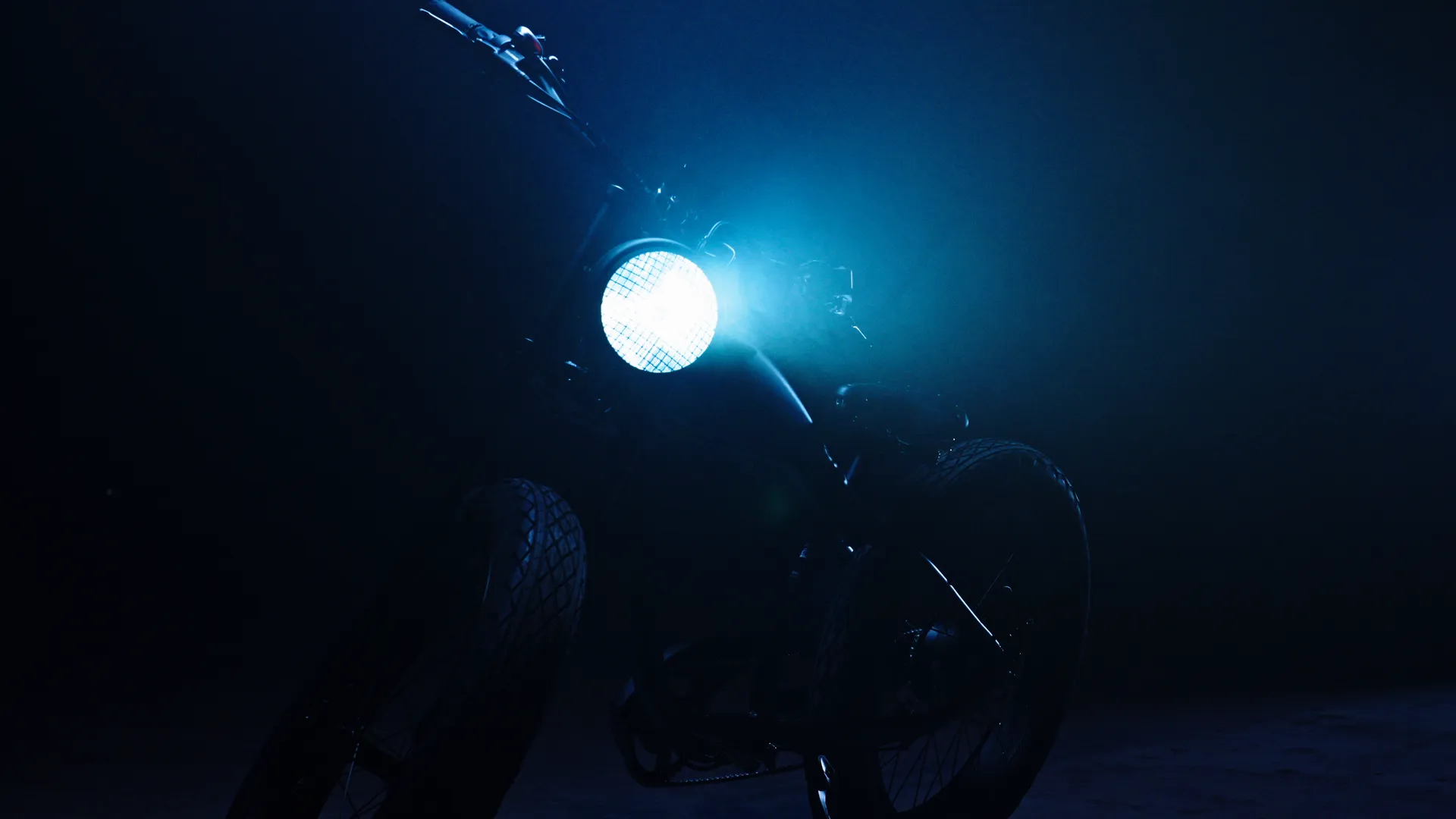The round headlight of the Destroyer e-bike glowing in the dark