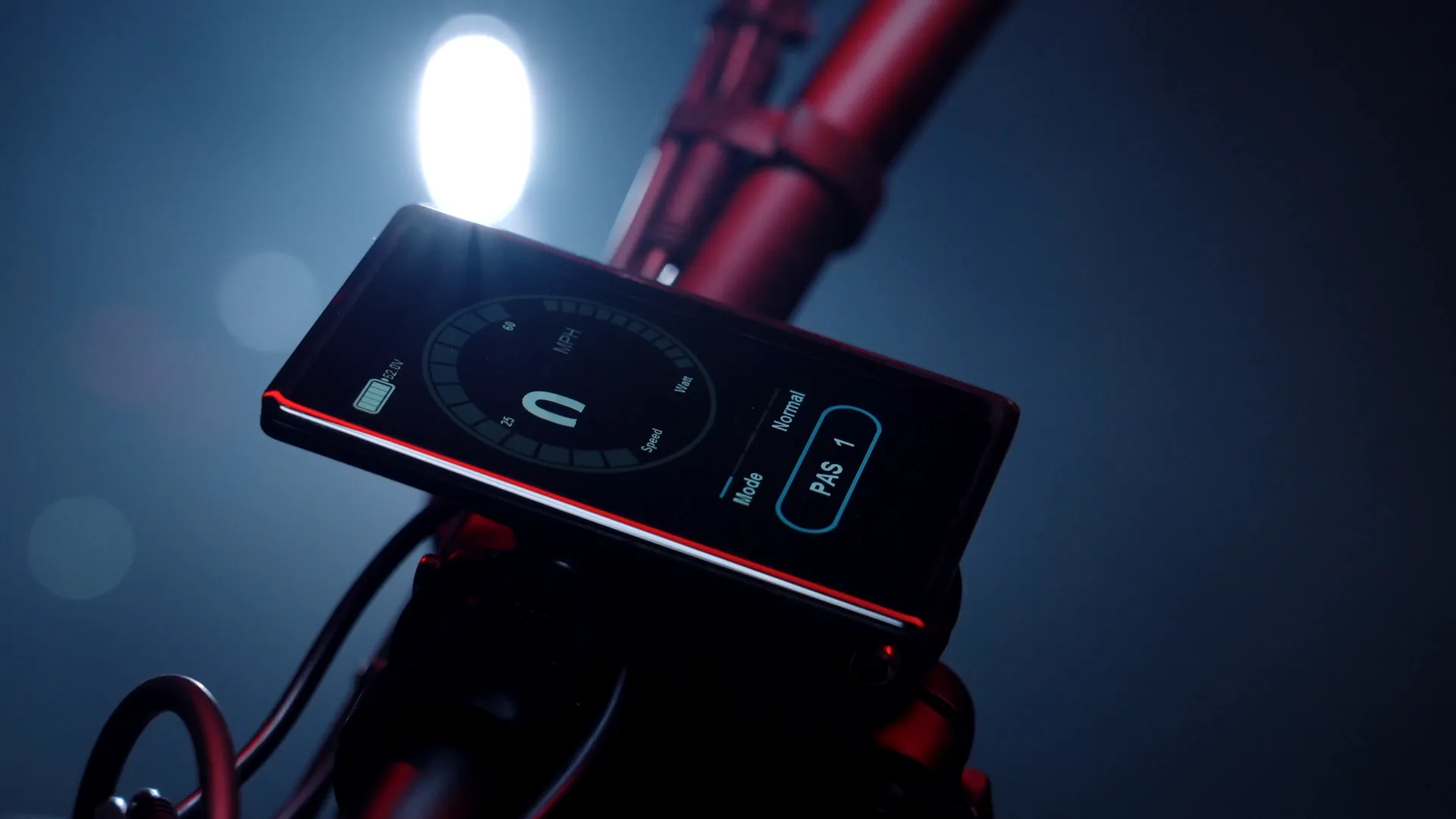The handlebar display glowing red under a work light