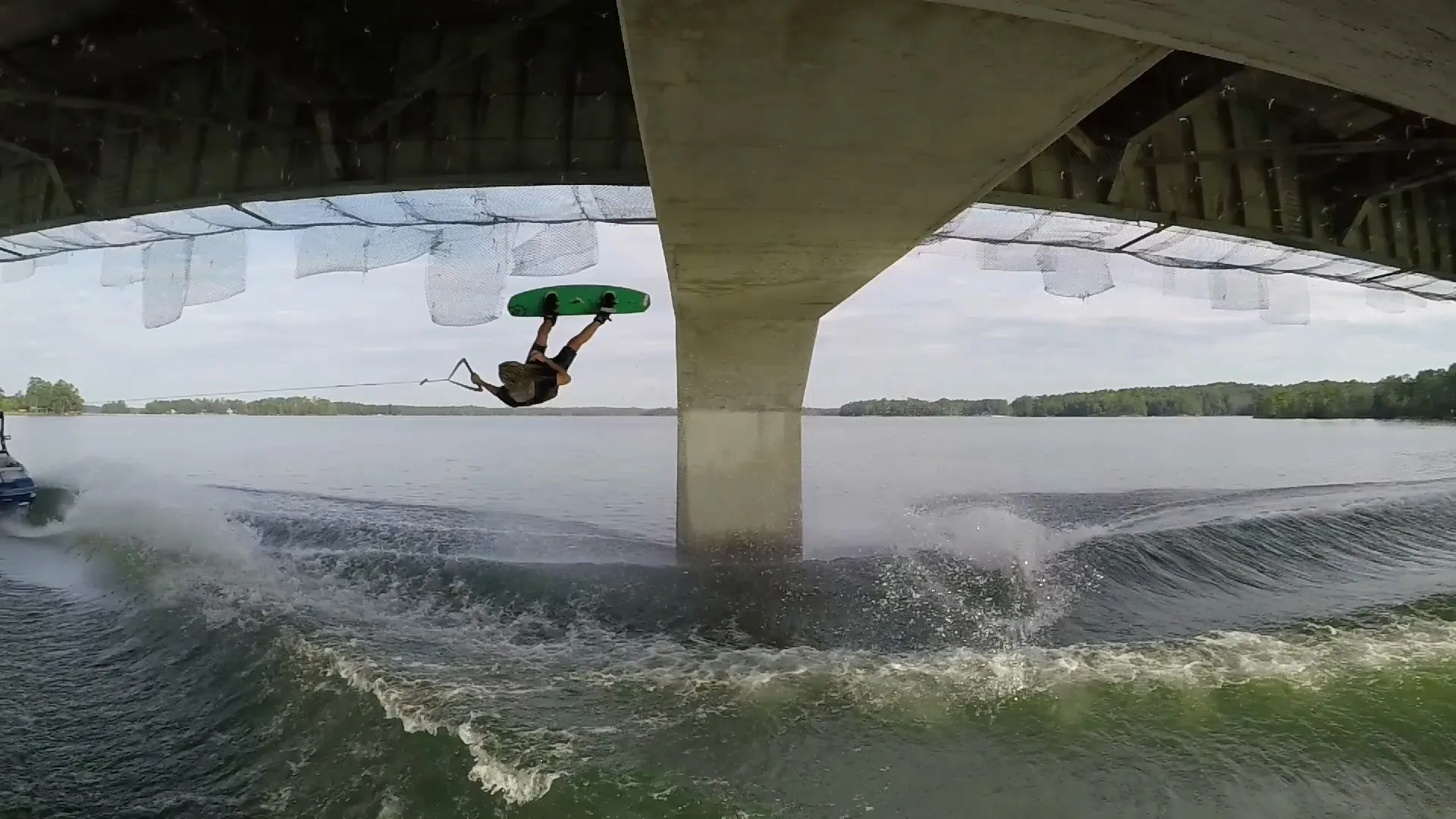 Alex Graydon upside down under a highway bridge, the board overhead
